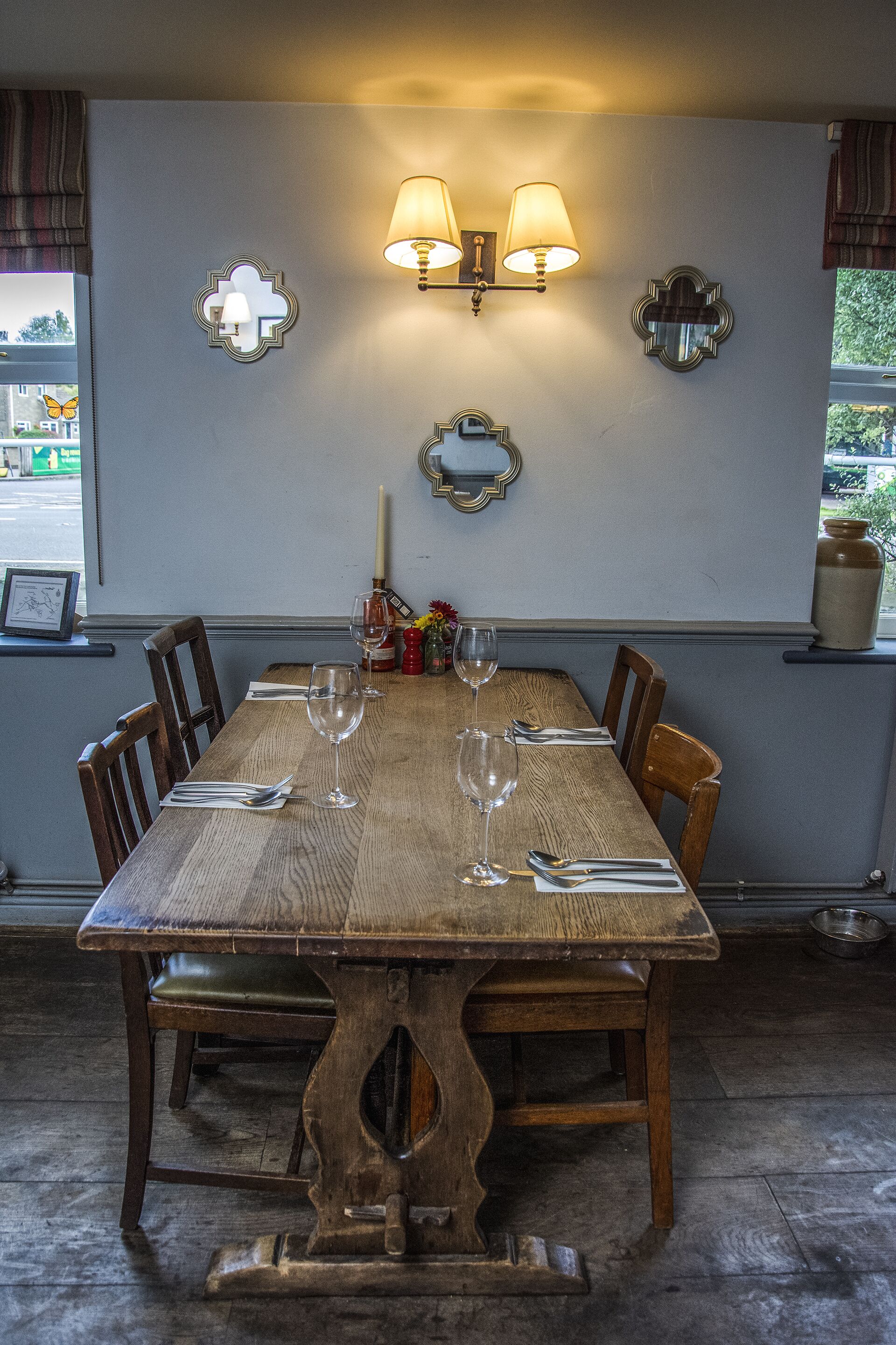 A wooden dining table with four chairs, set for a meal.