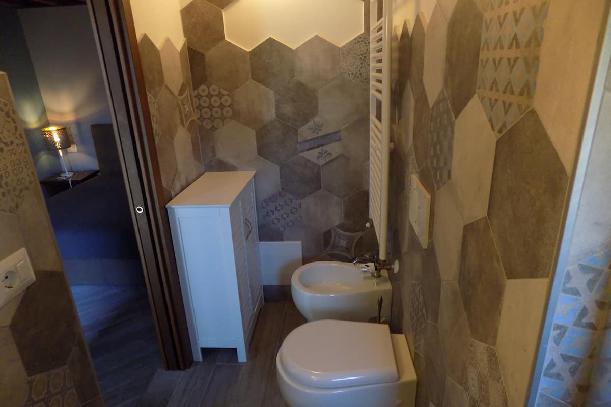 Un baño con inodoro, bidé y un armario.