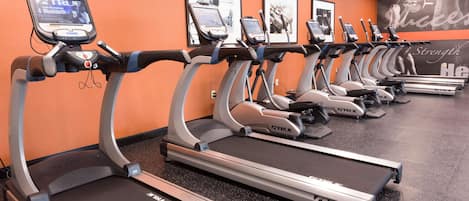A gym with multiple treadmills, each equipped with a digital display.
