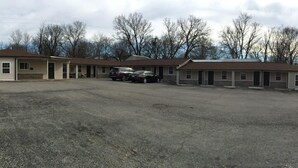 A motel with multiple rooms, a parking lot, and a sign advertising amenities like free WiFi.
