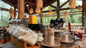 Un comptoir de cuisine de style rustique, agrémenté de bocaux de granola et de café, d’un mixeur et d’une machine à café.