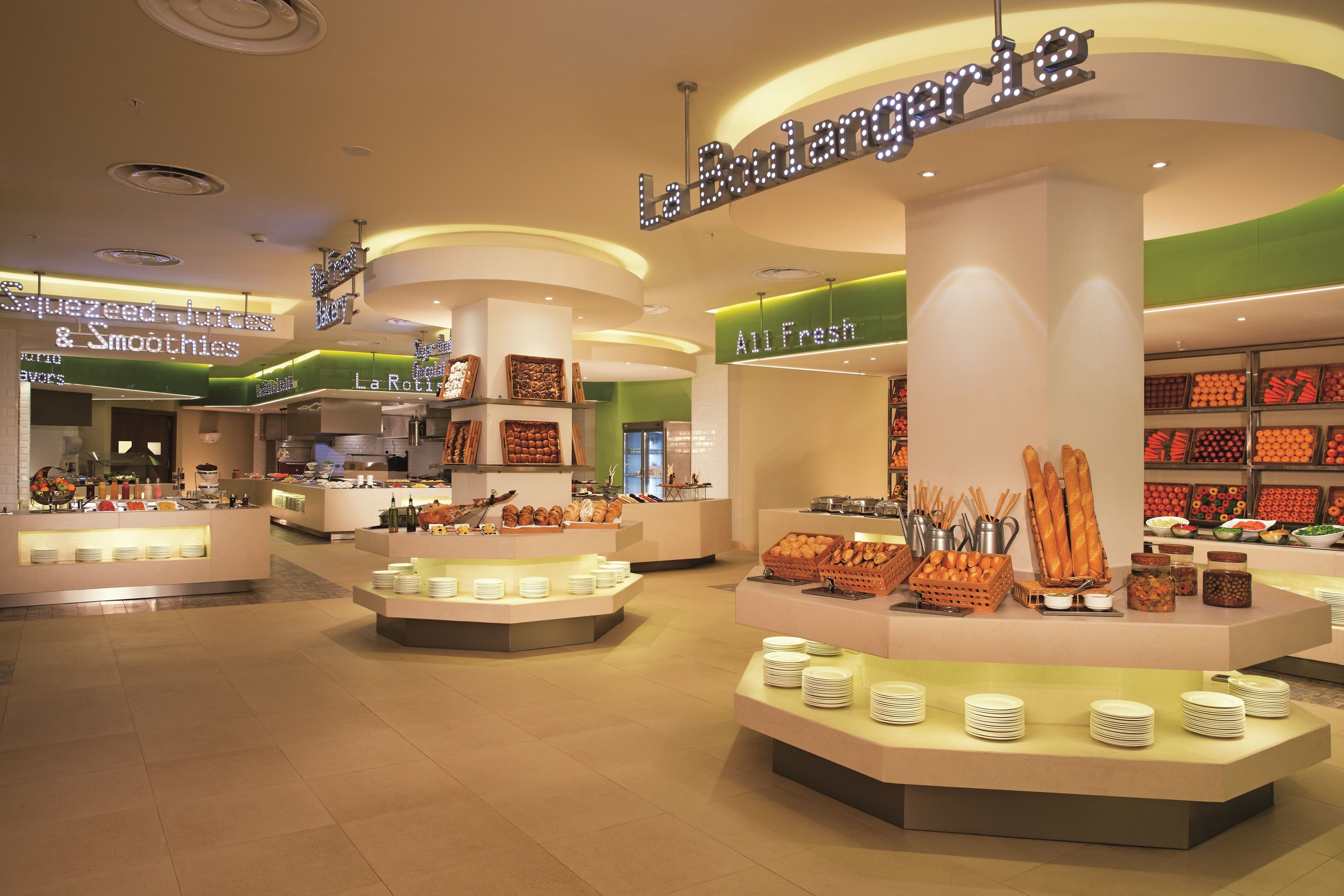 A buffet area with multiple food stations, including a section for fresh salads and a juice bar.