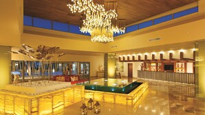 A spacious lobby with a central pool, a modern chandelier, and a seating area. - Dreams Onyx Resort & Spa All Inclusive (Punta Cana)