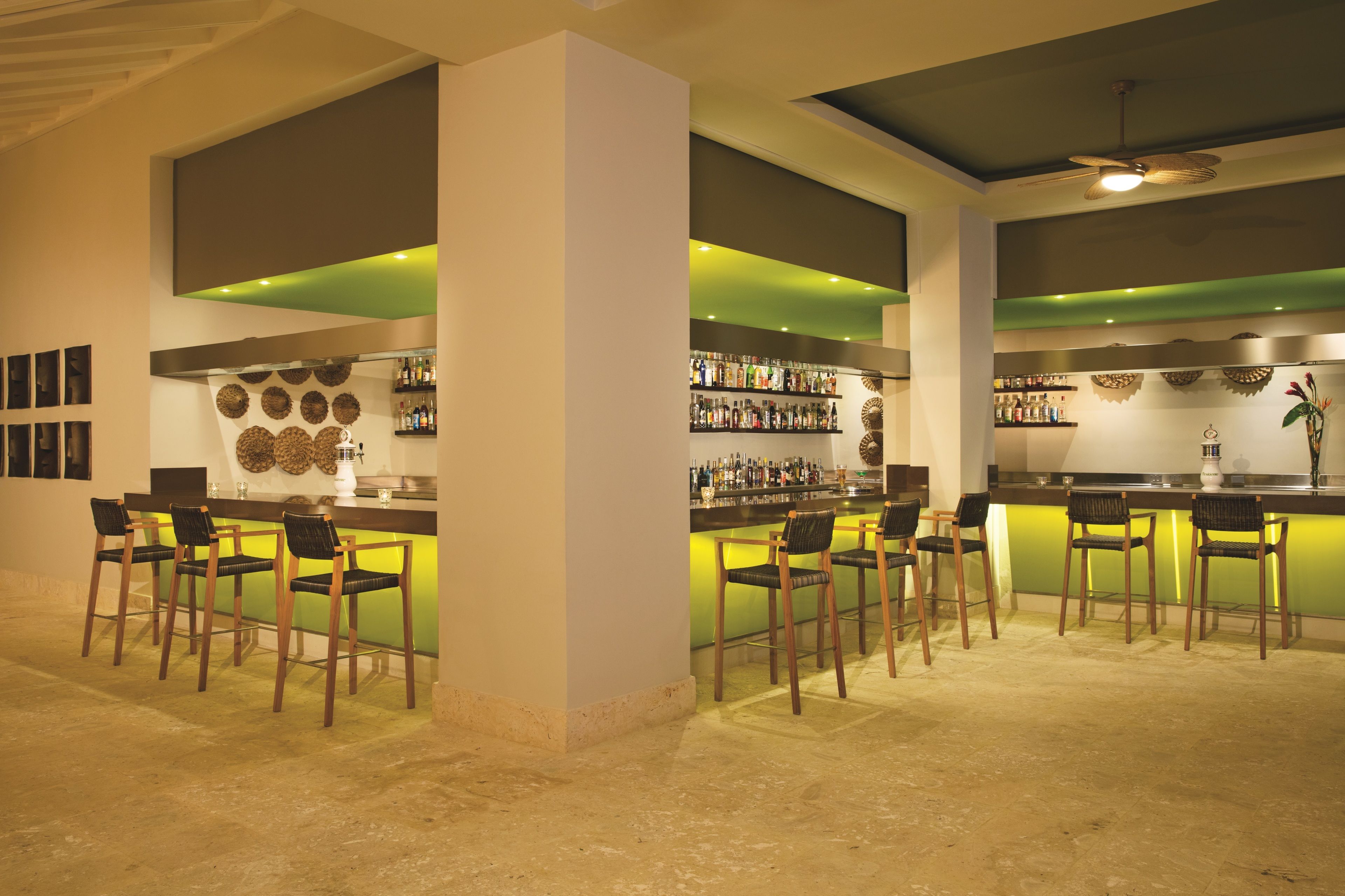 Un espace bar avec différents types de sièges et un comptoir bien garni.