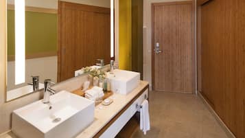A modern bathroom with two sinks, a mirror, and wooden doors.