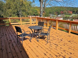 Eine Holzterrasse mit Tisch und Stühlen, umgeben von einem Geländer.