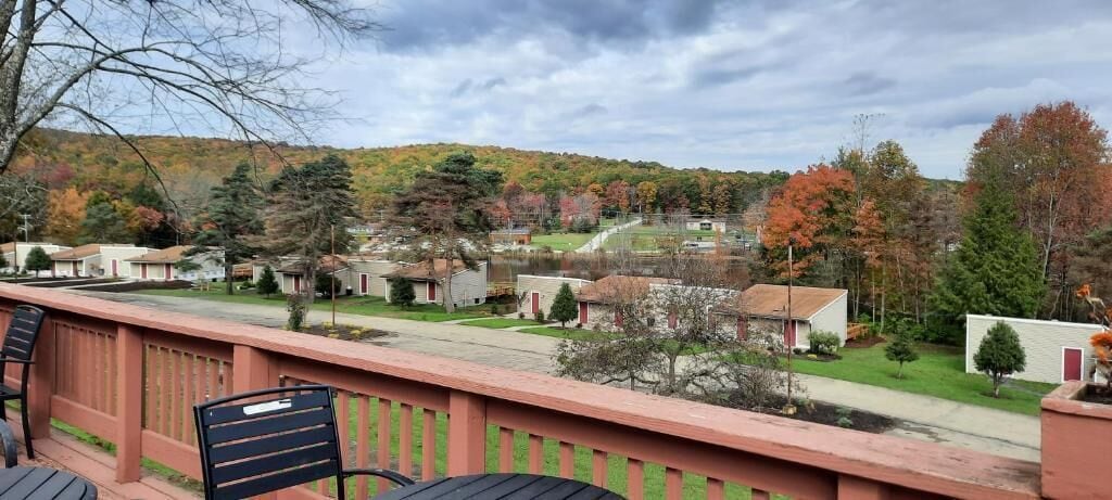 A residential area with houses, a clear sky, and a view of a hilly landscape.