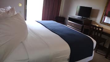 Habitació d'hotel amb un llit gran, una taula de treball amb televisió, una cadira i un mirall.