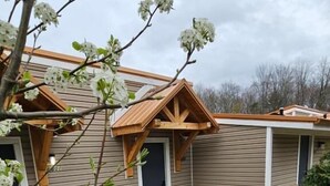 Un immeuble résidentiel doté d’un porche couvert, d’un pot de fleurs et d’un espace jardin aménagé.