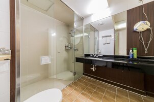 A modern bathroom with a glass-enclosed shower, a vanity with a black countertop, and a large mirror.