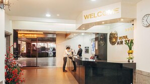 A hotel reception area with a 'WELCOME' sign, a clock, and a 'HOTEL AIR STAY' sign.