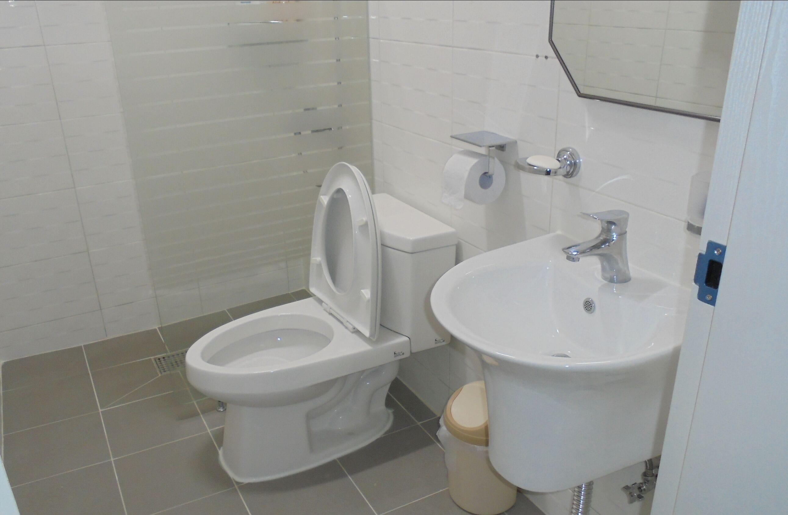 A modern bathroom with a toilet, sink, and mirror.