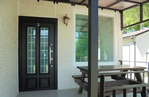 A black door with a number '2' above it, a glass panel, and a light fixture on the wall. - Santa Fe Pension (Namhae)