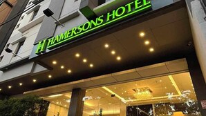 Una entrada de hotel moderna con un letrero llamativo que dice "HAMEKSONS HOTEL".