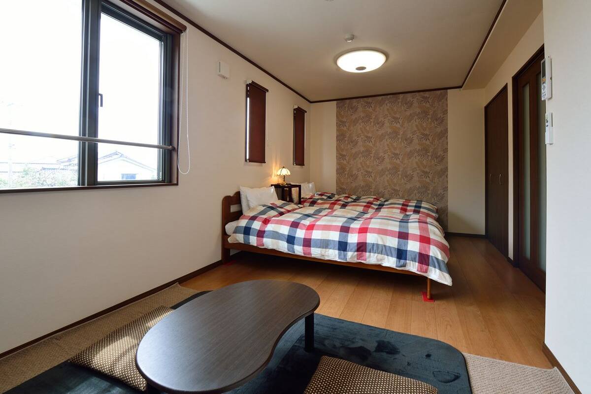 A compact bedroom with a bed, bedside table, and a window.