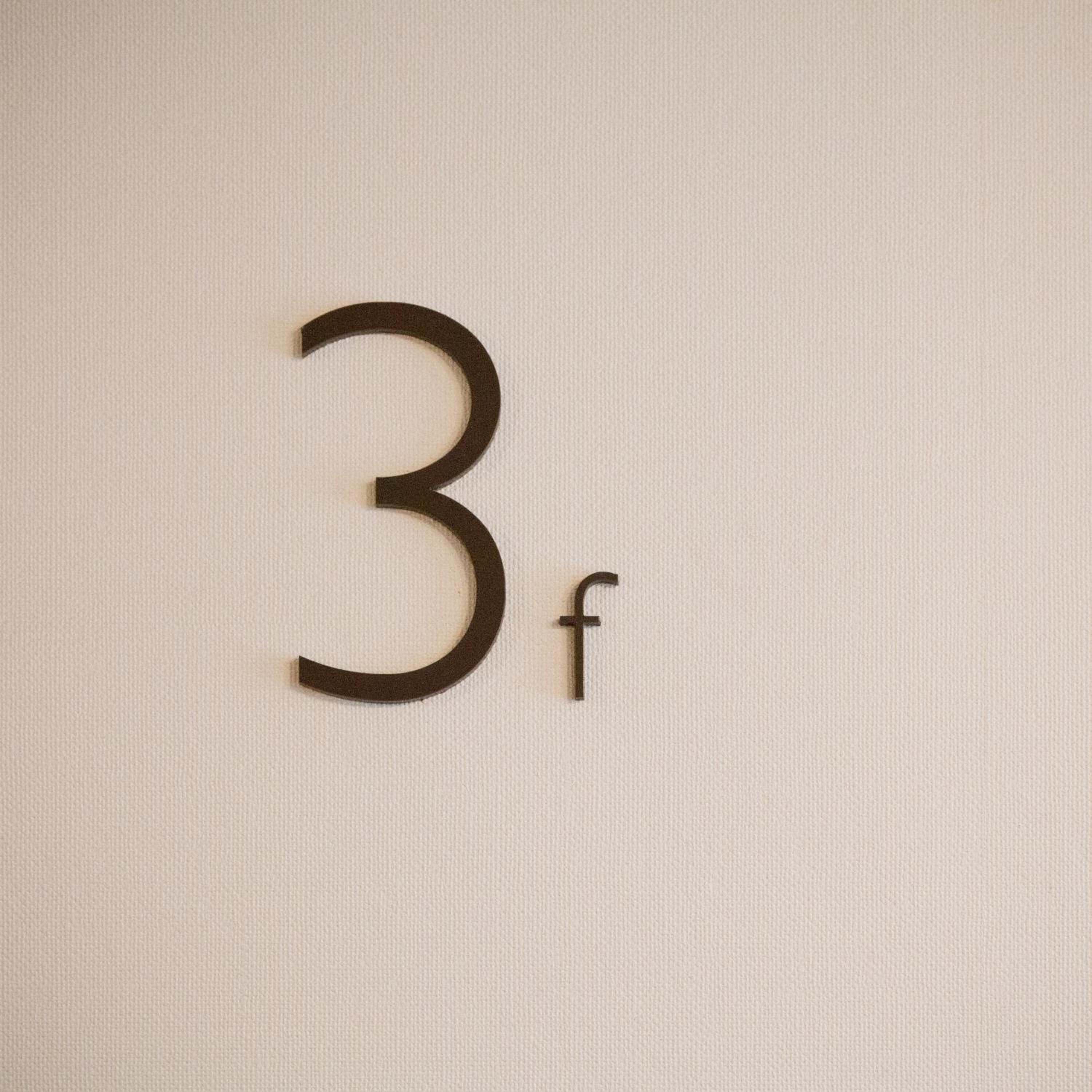 En vägg med ett stort, framträdande siffran ”3” och en liten bokstav ”f” till höger.