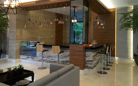 A modern lobby with a reception desk, seating area, and a view of the outdoors.