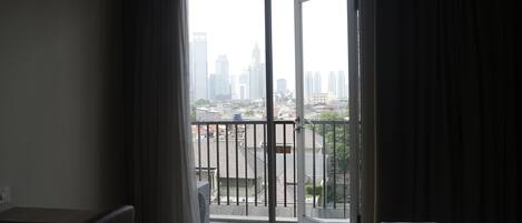 A hotel room with a balcony overlooking a cityscape.