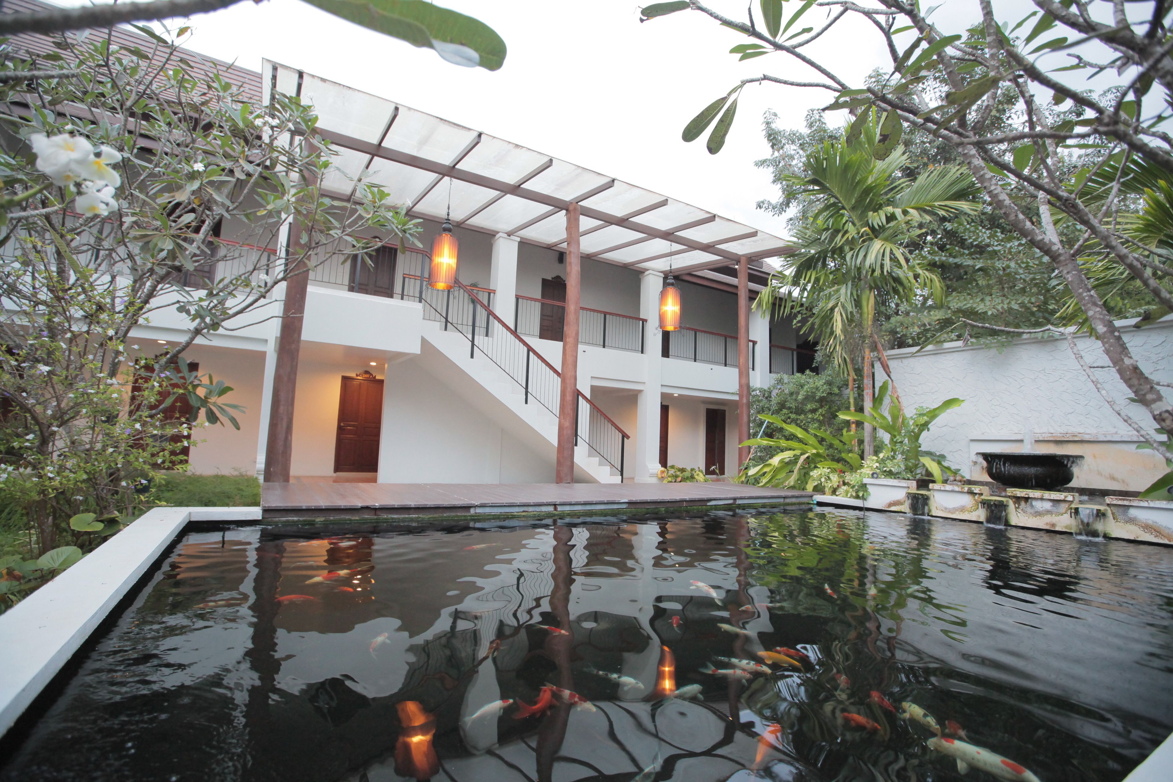 A modern building with a pool, koi fish, and outdoor lighting.