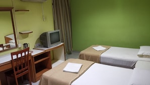 Camera d'albergo con scrivania, televisore, due letti, uno specchio e condizionatore d'aria.