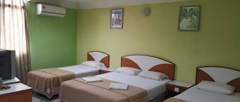Habitación de hotel con dos camas, un escritorio, una silla y un televisor.