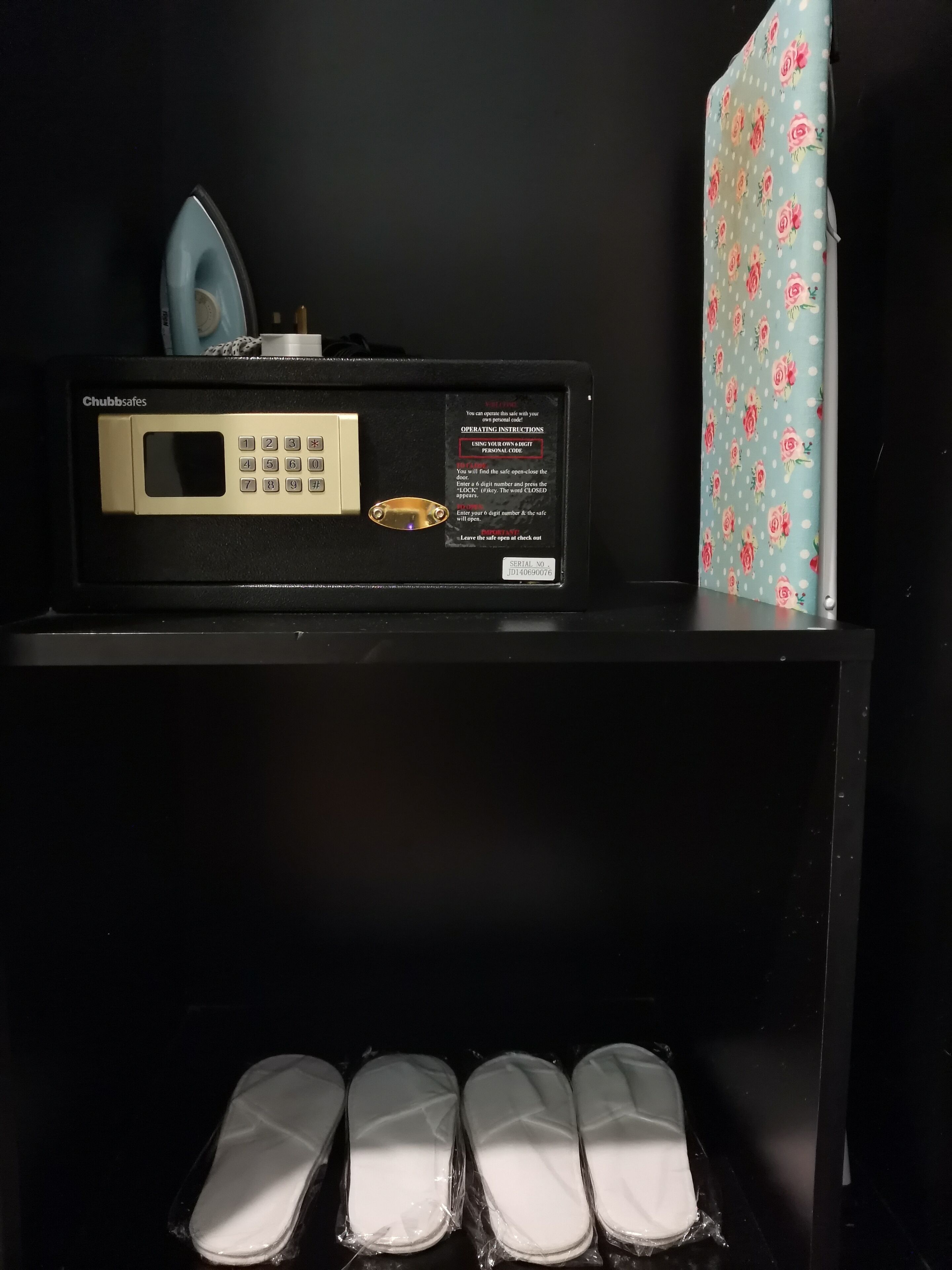 A Chubb safes with a keypad and instructions, a floral-patterned item, and four white shoe boxes.