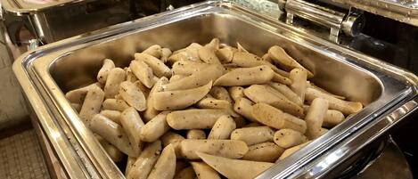 Un buffet proposant une variété de plats, notamment des viandes en tranches et des pâtes.
