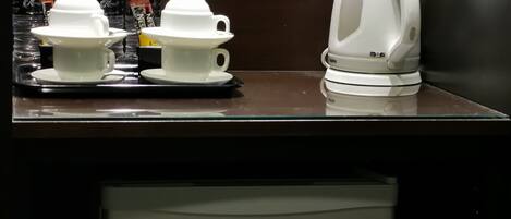 A coffee station with disposable cups and a coffee machine, and a refrigerator labeled "Hisense" below.