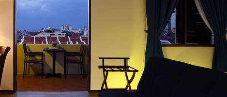 A room with a balcony, a sofa, and a small table.
