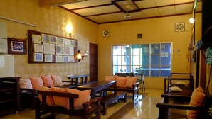 A traditional Japanese-style room with tatami flooring, wooden furniture, and a bulletin board with various notices. - TnT Novelty House (Teluk Intan)