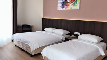 A hotel room with two beds, a desk, a chair, and a painting on the wall.