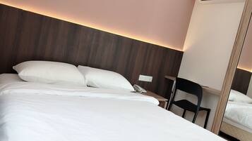 Quarto de hotel com uma cama grande, mesa de cabeceira com telefone, uma cadeira e um espelho.