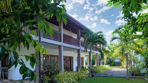 A two-story building with a balcony, surrounded by lush greenery and palm trees. - Hikka Resort (Hikkaduwa)