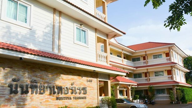 A multi-story hotel with a stone facade and balconies. - Nuntiya Terrace (Udon Thani)