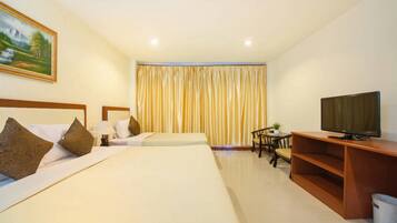A hotel room with two beds, a television, a desk with a chair, and a large window with curtains.