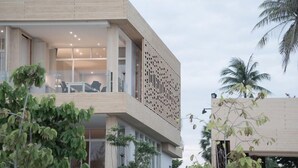 A modern building with a flat roof, large windows, and a balcony with seating. - Tri-Shawa Resort (Prachuap Khiri Khan)