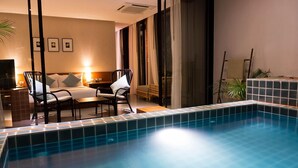 A hotel room with a swimming pool, a sofa, a chair, and a bed. - Tri-Shawa Resort (Prachuap Khiri Khan)
