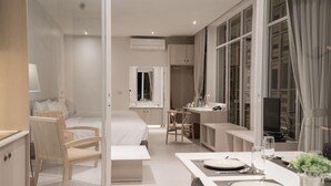 A modern hotel room with a bed, a desk, and a dining area. - Tri-Shawa Resort (Prachuap Khiri Khan)