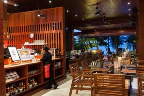 A restaurant with wooden furniture and a view of the sea. - Tri-Shawa Resort (Prachuap Khiri Khan)