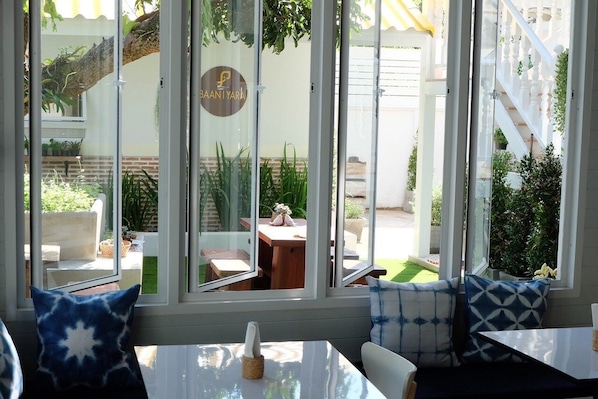 Ein Restaurant mit Außenbereich, einem Schild mit der Aufschrift "BAANTIYARA" und Blick auf einen Garten und eine Treppe.