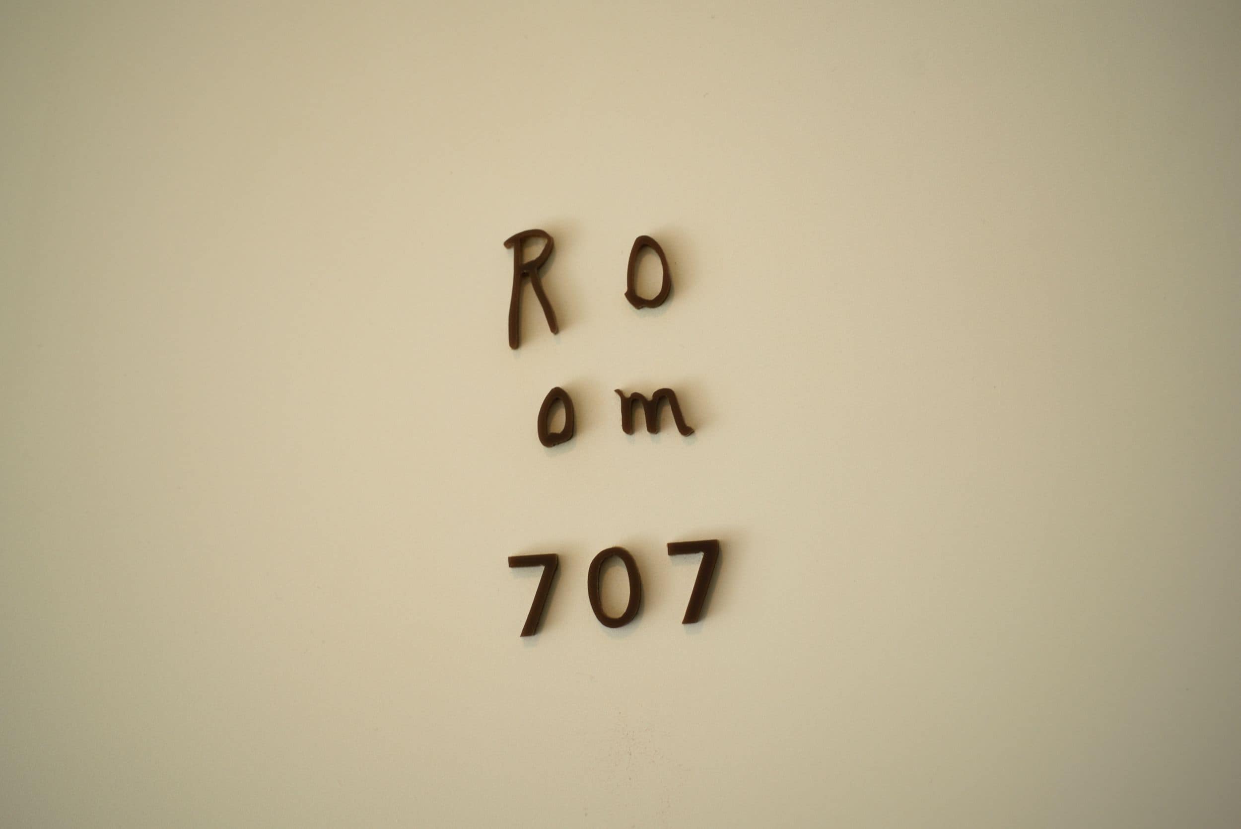 Paredes com o texto "Room 707" numa fonte simples e sem serifa.