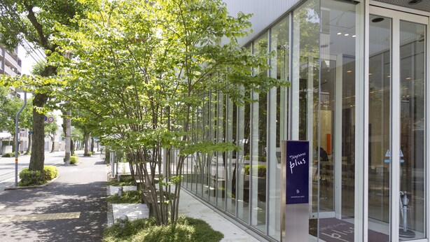 A modern building with large glass windows, a clear pathway, and a signboard. - 7 Days Hotel Plus (Kochi)
