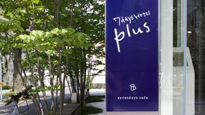 A sign for '7days Hotel Plus' with a bicycle parked nearby. - 7 Days Hotel Plus (Kochi)