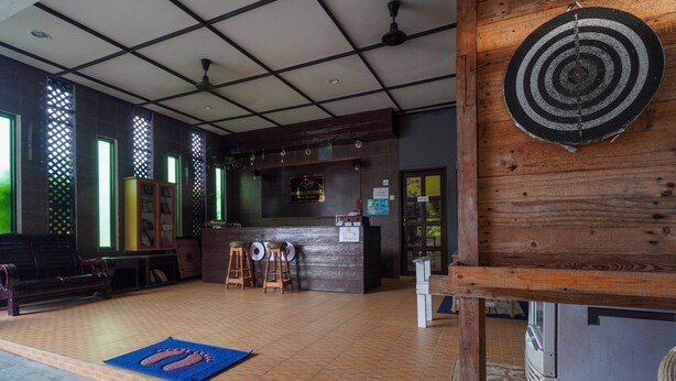 A reception area with a wooden counter, a dartboard, and a reception desk. - OYO 89646 Panvill Resort (Pangkor Island)