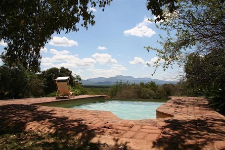 Una piscina al aire libre, sillones reclinables de piscina