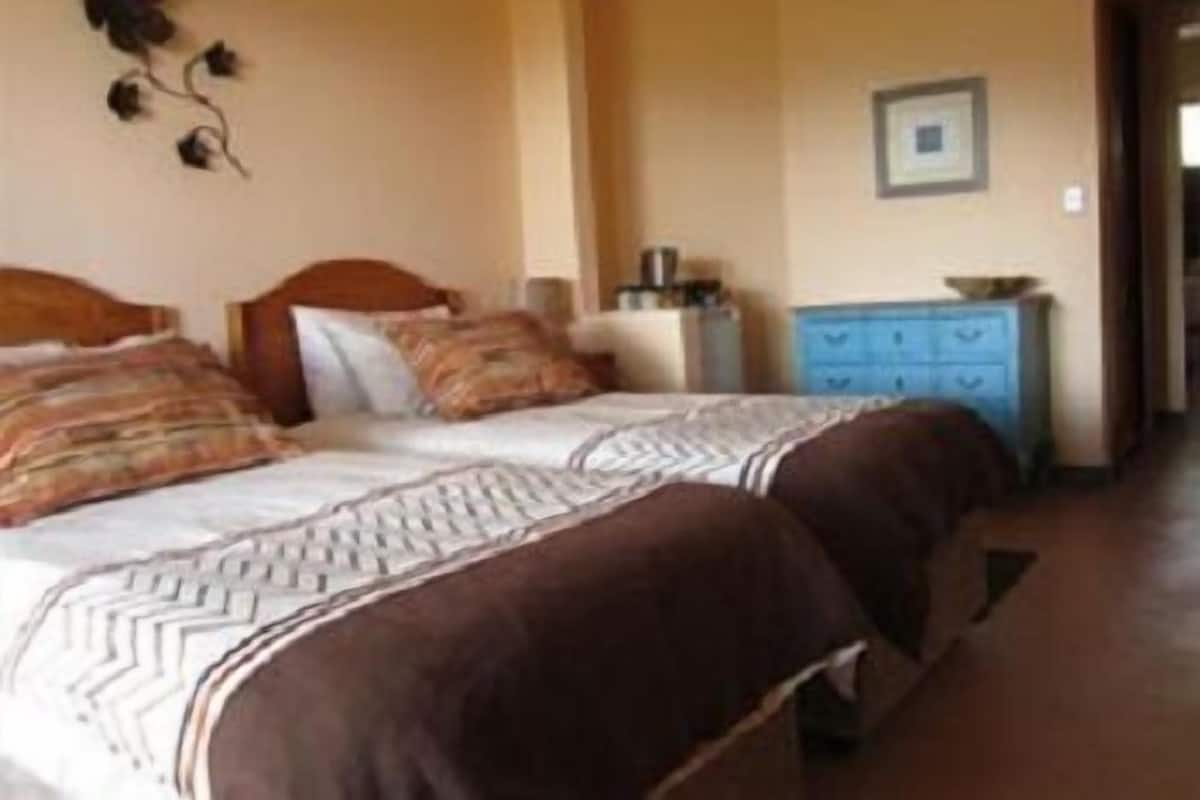 A bedroom with a double bed, a dresser, and a wall-mounted decoration.