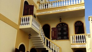 A two-story building with a central staircase, multiple balconies, and arched doorways. - River Park Homestay and Hostel (Da Nang)
