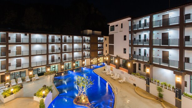 A multi-story hotel with a swimming pool, balconies, and outdoor seating areas. - The Lai Thai Luxury Condominiums (Krabi)