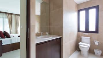 Un baño moderno con lavamanos doble, inodoro y espejo grande.