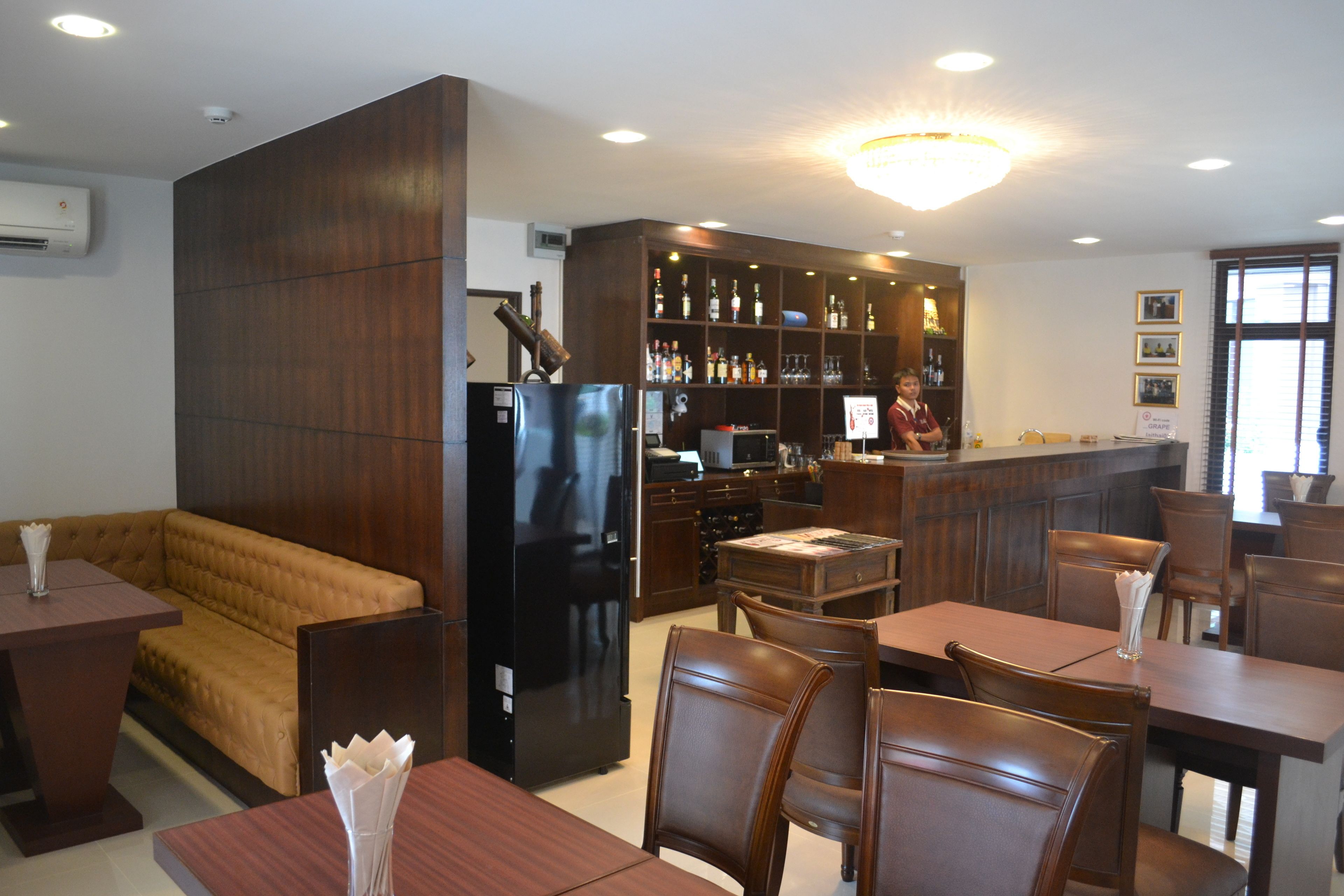 Ein Restaurant mit Holzkubaturen, einer Bar und einer Küche im Hintergrund.